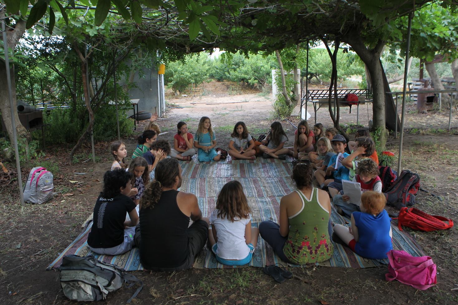 ילדים יושבים במעגל על מחצלת